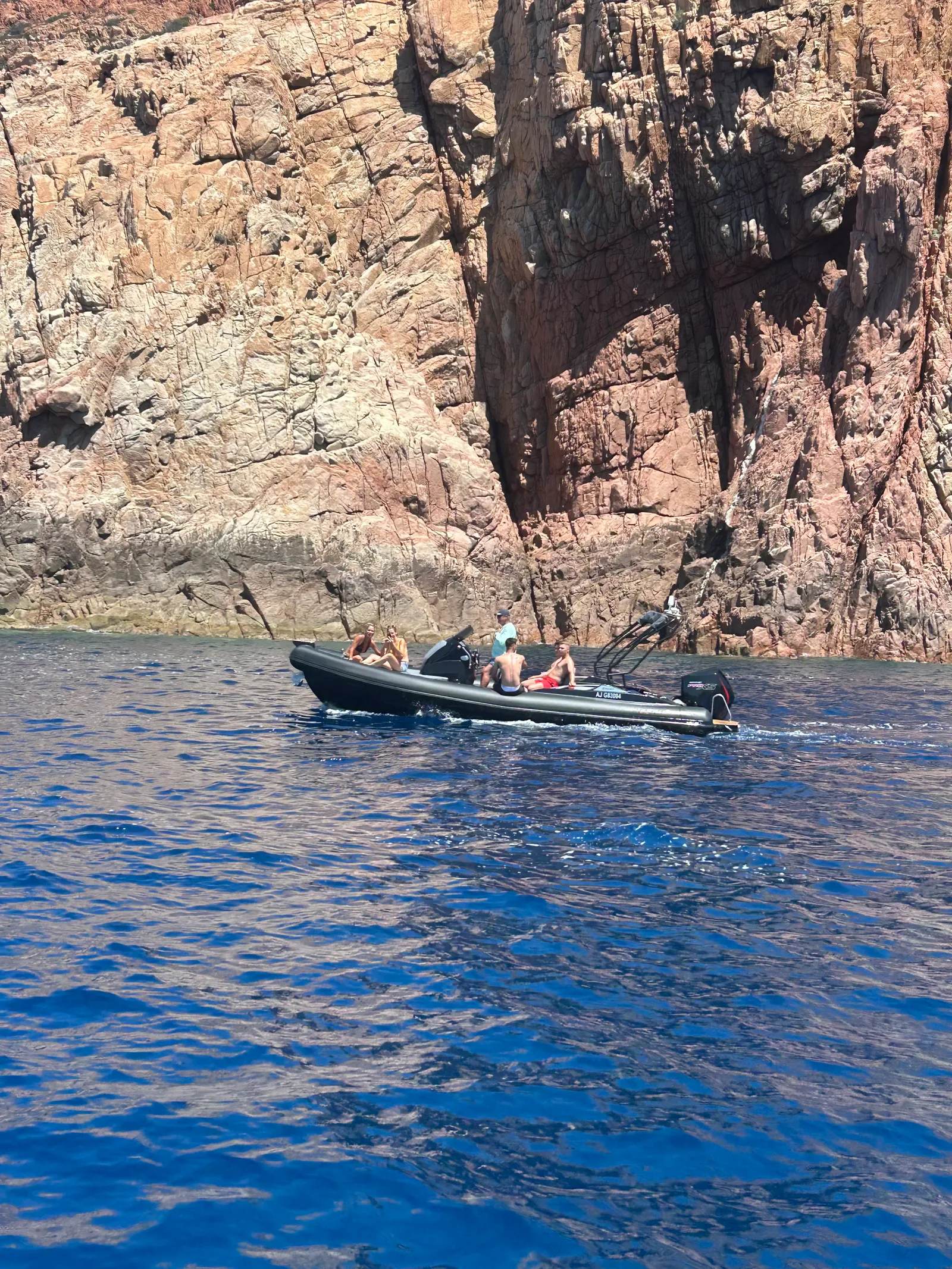 Le semi-rigide SPX 25 au large, devant les falaises rouges de Corse